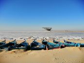 Ice Floes on Ocean and Blue Boats on Shore