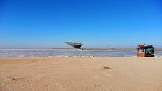 Ice Floes on Ocean and Sandy Shore Under Blue Sky