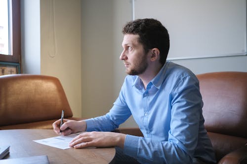 Thoughtful man thinking on business strategy and making notes