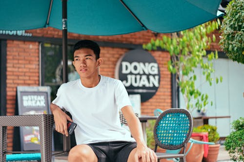 Free Pensive young ethnic man resting in outdoor cafe Stock Photo