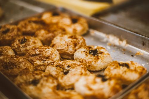 Free Close-up of freshly baked pastries arranged on a metal tray, showcasing texture and detail. Stock Photo