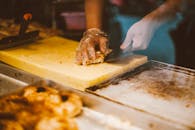Person Slicing Bread on Chopping Board