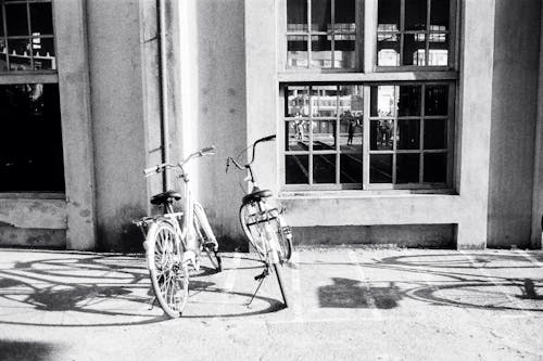 Bicycles parked on sidewalk near concrete building