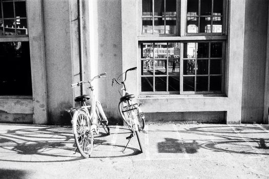 Bicycles parked on sidewalk near concrete building