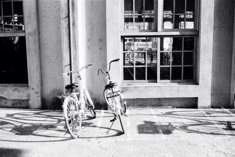 Bicycles Parked On Sidewalk Near Concrete Building