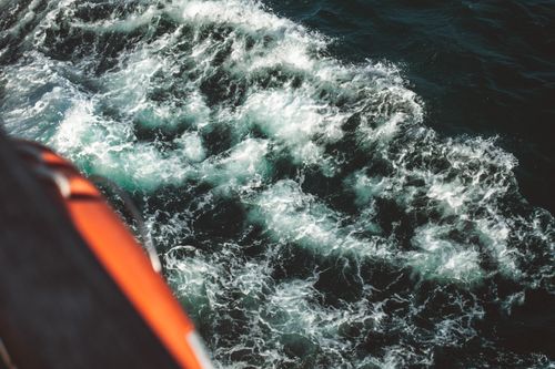 Free Exciting view of ocean waves splashing against a boat, capturing the energy of the sea. Stock Photo