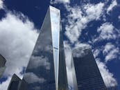 现代摩天大楼在清澈的蓝天中呈现出令人惊叹的低角度透视，并映出云影