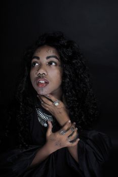 Artistic portrait of a black woman with tattoos and jewelry, expressing intricate style.