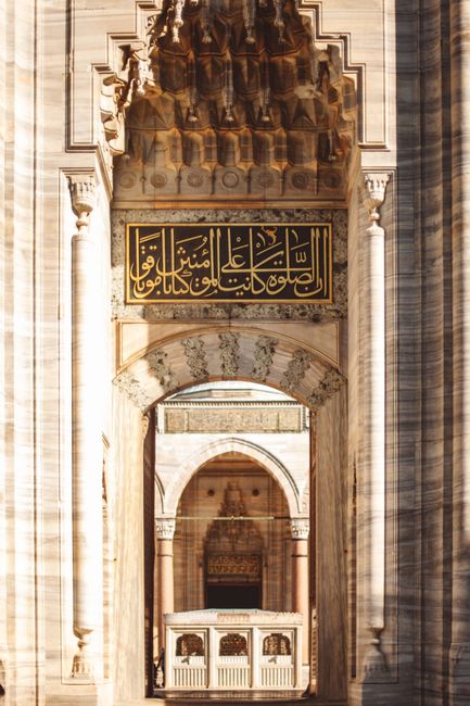Intricate stone doorway of the historic Süleymaniye Mosque in Istanbul, showcasing Islamic architecture.