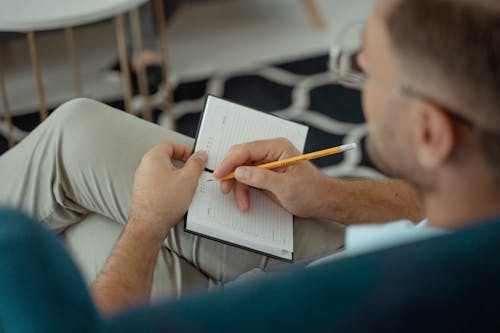A Man Writing on a Notebook