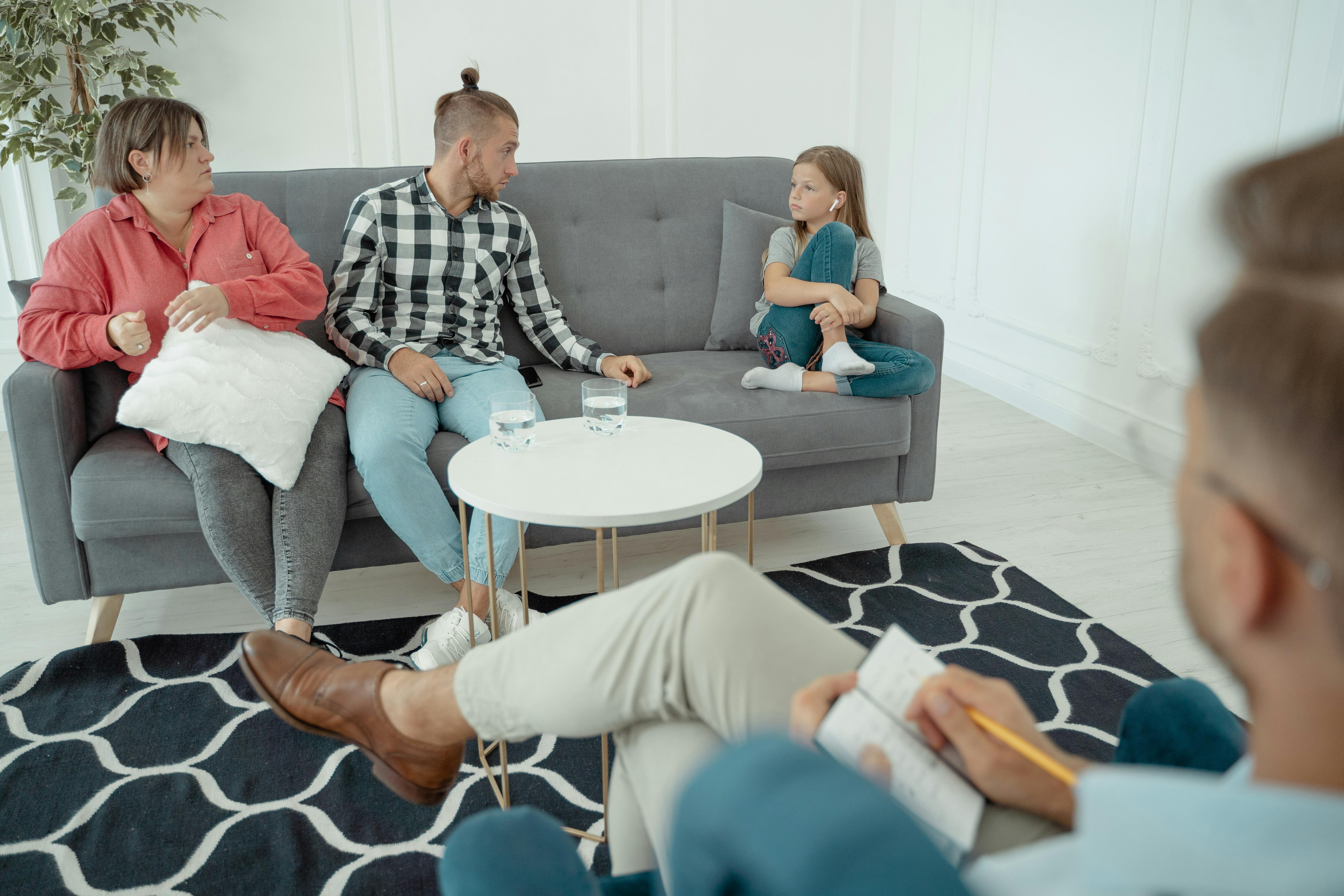 a family sitting on the couch seeing a counselor