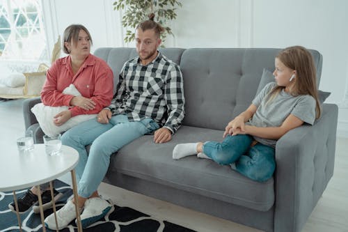Free A Family Sitting on a Couch  Stock Photo