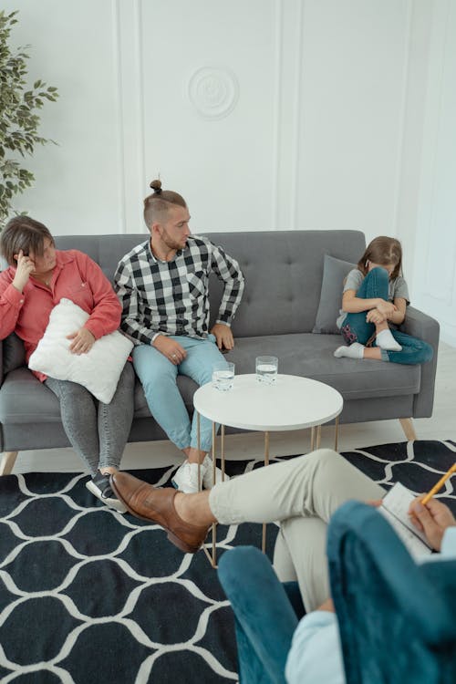 Free A Couple Sitting on a Couch with their Daughter at a Therapy Session Stock Photo