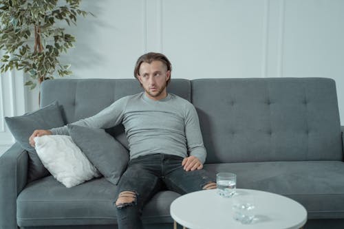 Man in Gray Long Sleeve Sitting on Gray Couch