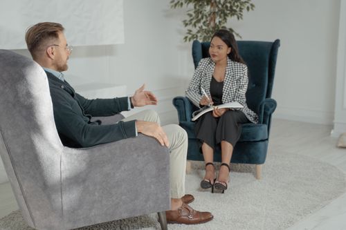 Free Businessman and woman in discussion during a formal office meeting. Stock Photo