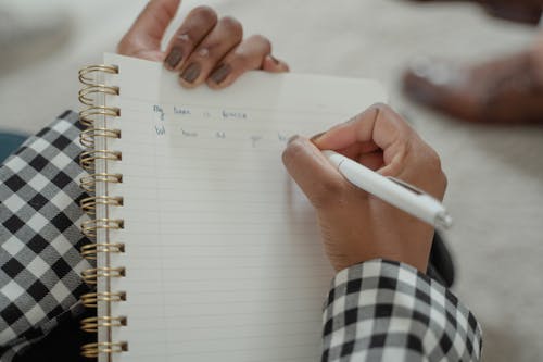 Foto profissional grátis de caderno, caneta, escrevendo
