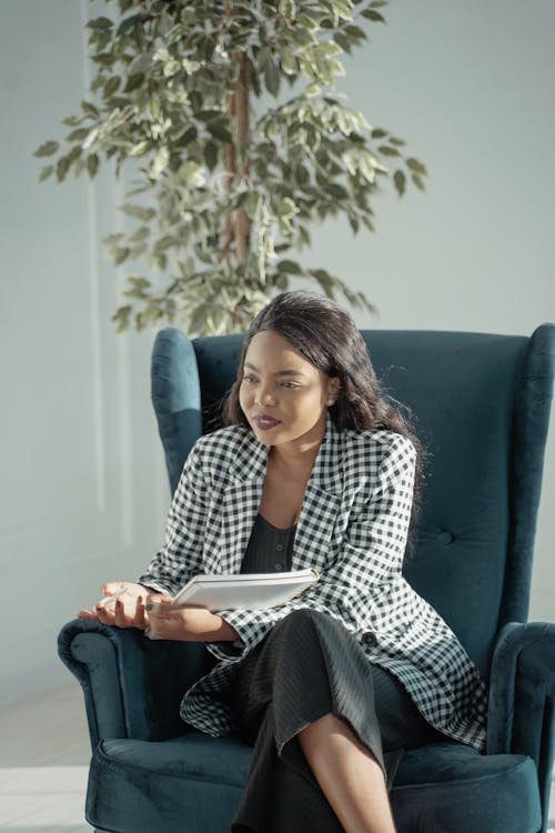 Woman in Black and White Checkered Dress Shirt Sitting on Blue Couch