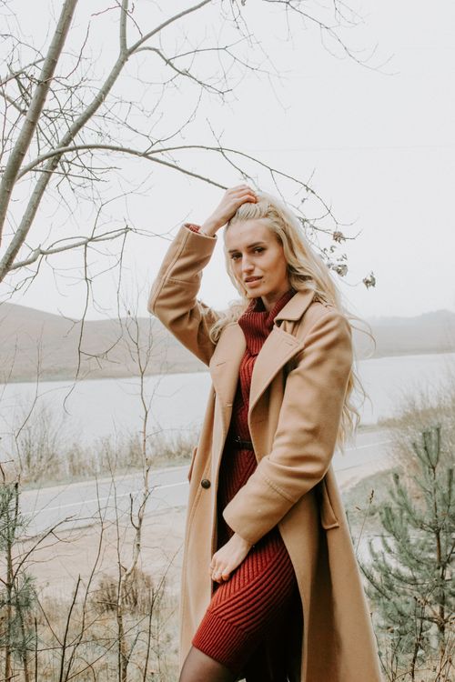 Free Elegant woman poses by a lakeside in autumn attire in Minsk, Belarus. Stock Photo