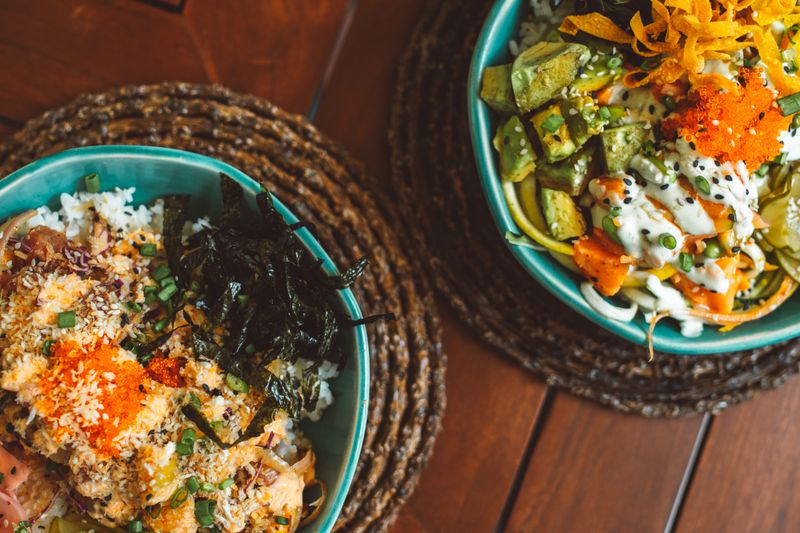 Colorful bowls with fresh sushi and poke ingredients