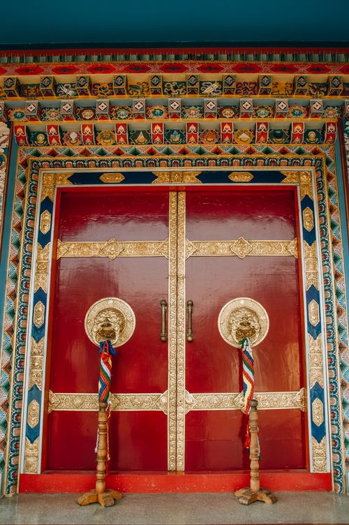 Free Beautiful traditional red temple doors with intricate gold decorations and vibrant colors. Stock Photo