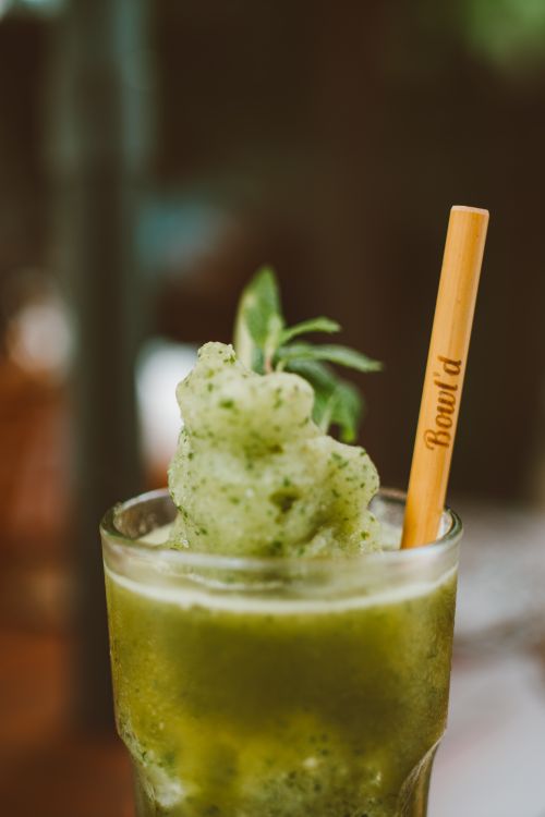 Free Close-up of a refreshing green smoothie in a glass with a bamboo straw. Stock Photo