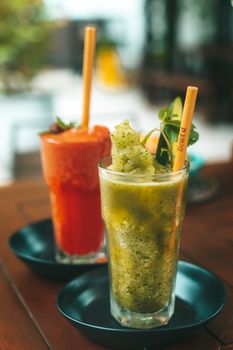 Chilled fruit smoothies with mint and bamboo straws for a refreshing summer drink.