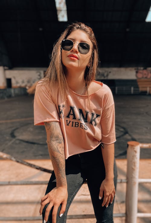 A Woman in Pink Crew Neck T-shirt and Black Pants Wearing Sunglasses