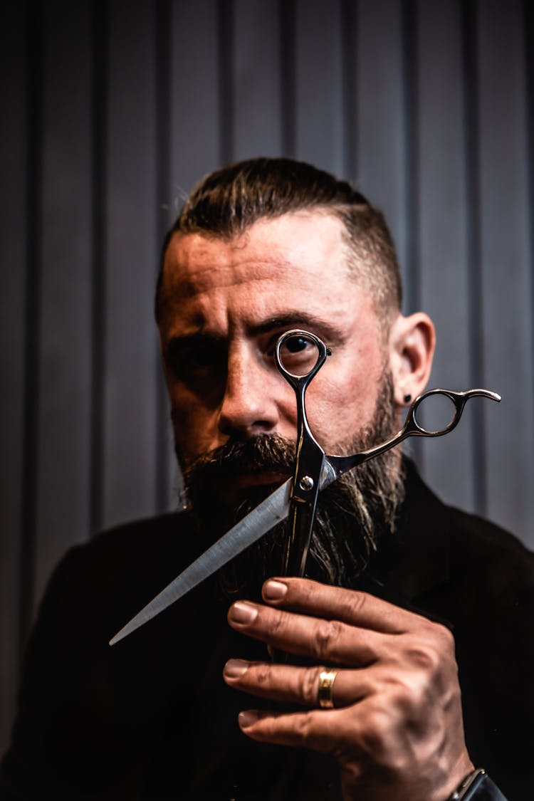 A Bearded Man Holding A Scissors