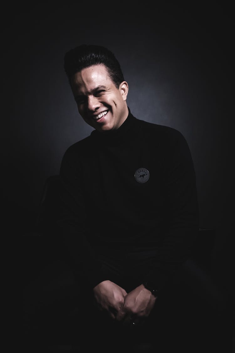 A Smiling Man Wearing A Black Turtleneck