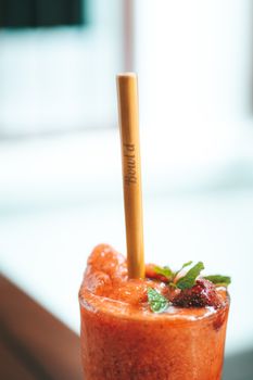 特写镜头：玻璃杯中的清凉草莓冰沙，用竹管装饰