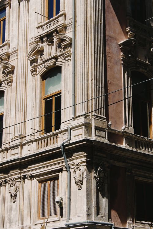 Free Close-up view of a Baroque building facade with ornate columns and windows. Stock Photo