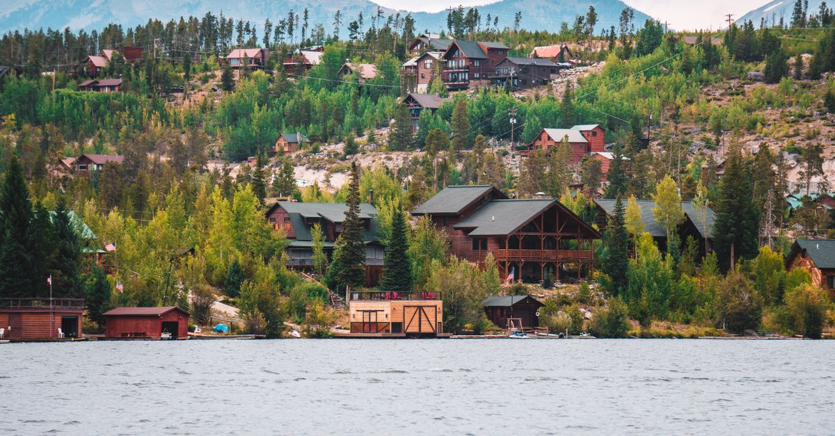 Charming lakeside cabins nestled among trees in a mountainous region. Beautiful nature scenery.