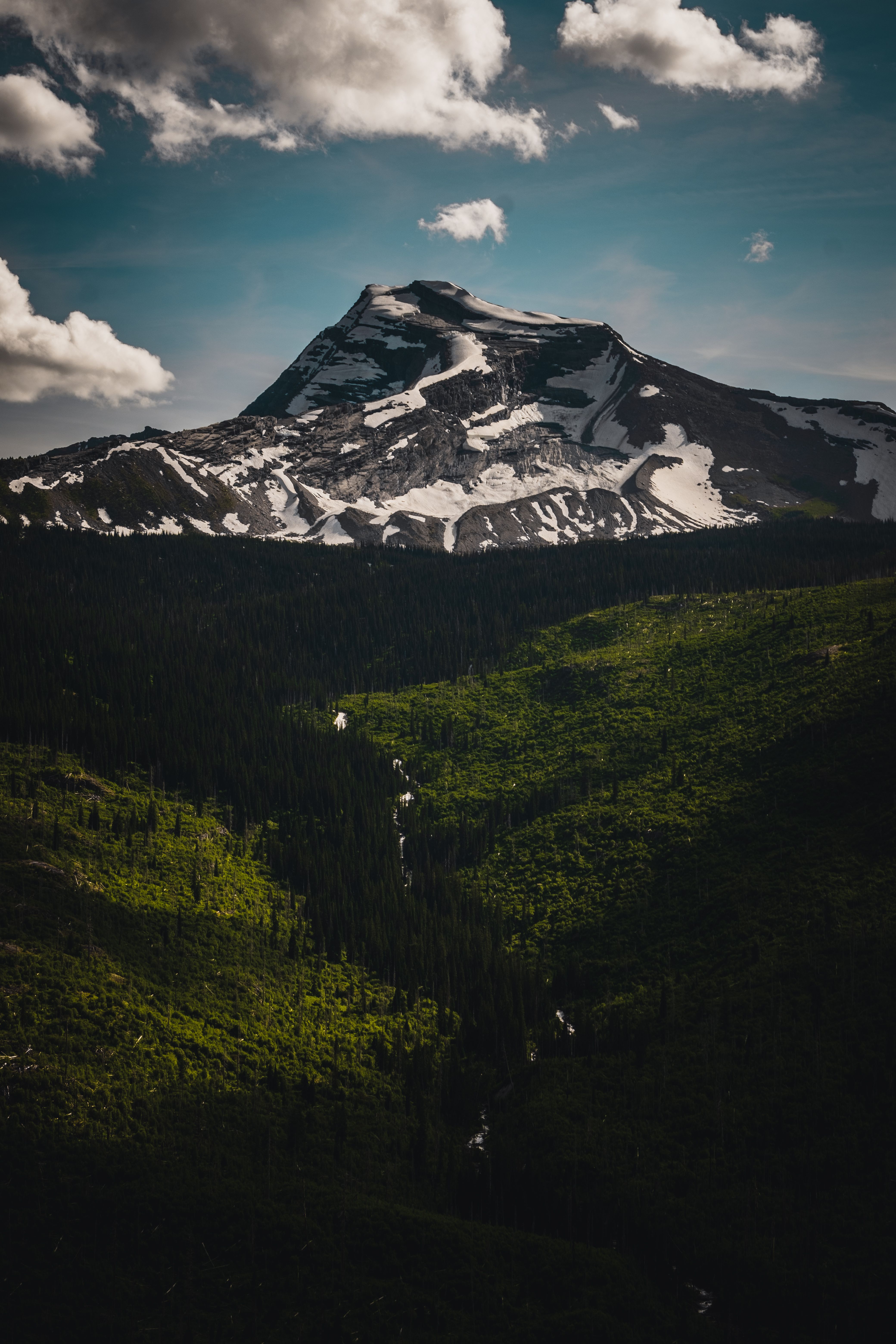Sunrise over alpine peaks and a winding mountain road near Logan Pass in Glacier National Park