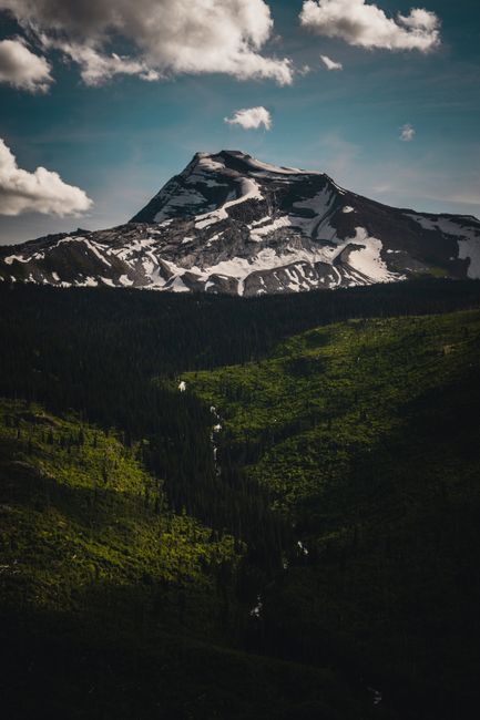 Sunrise over alpine peaks and a winding mountain road near Logan Pass in Glacier National Park