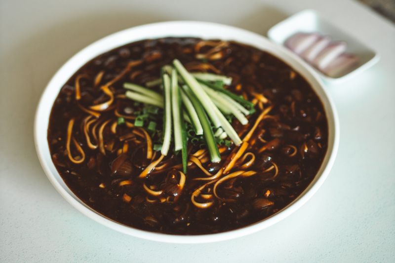 Bowl of jajangmyeon black bean noodles with toppings