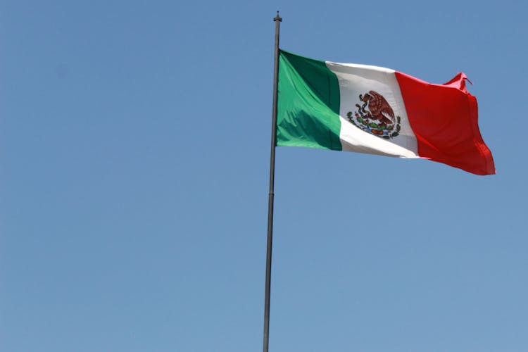 A Mexican Flag Blowing With The Wind