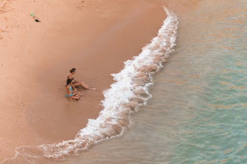 Free Mother and Daughter Sitting on Shore Stock Photo