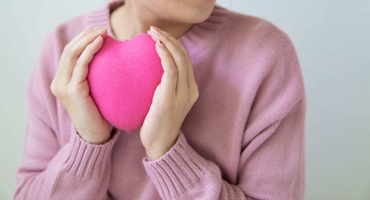 Free Crop woman with pink heart in hands. Stock Photo