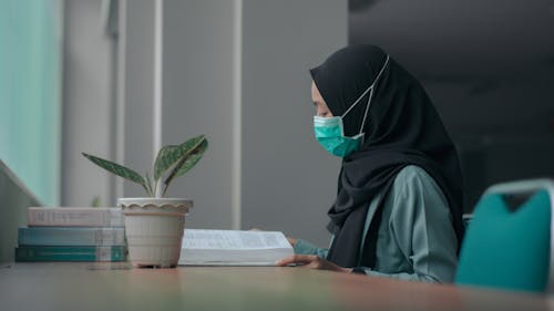 grátis Foto profissional grátis de coronavírus, hijab, lendo um livro Foto profissional