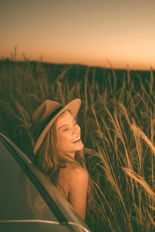 Happy woman in field at sunset