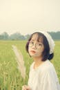 Woman in White Top Holding a Grass