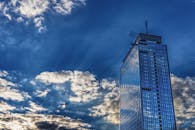 一座现代摩天大楼高耸入云，映照着蓝天