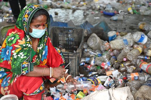 Free A woman in Chattogram sorts plastic bottles, highlighting recycling efforts and waste management. Stock Photo