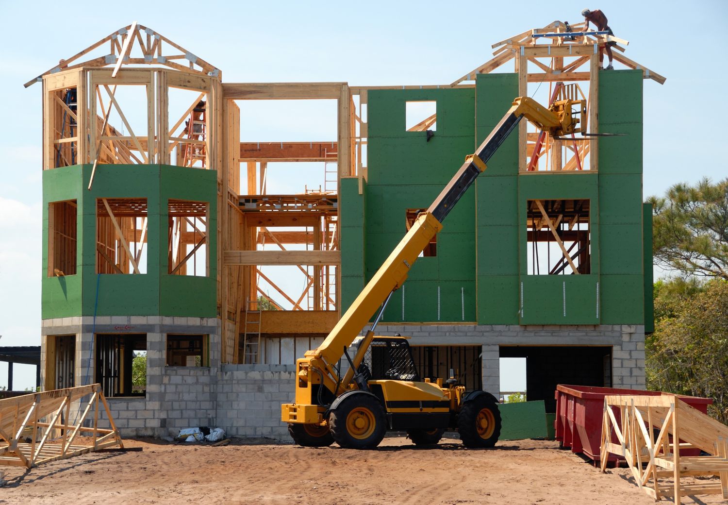 A multi-story wooden house under construction using a crane