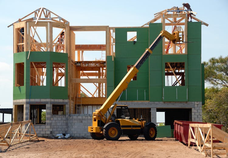 Yellow And Black Heavy Equipment Near Unfinished Building