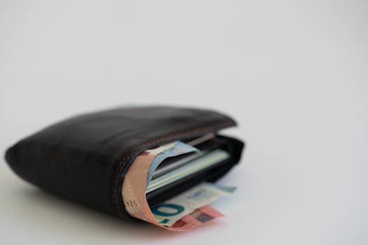 Close-up of a leather wallet filled with Euro banknotes on a white background, perfect for financial and lifestyle themes.