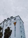 Exterior of residential house with painted zip on white walls near windows under cloudy sky