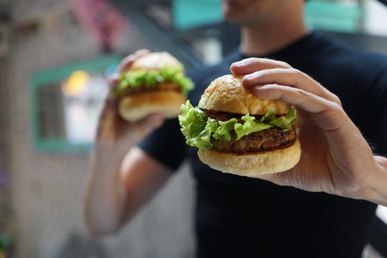 Two people holding burgers — photo by Pixabay on Pexels