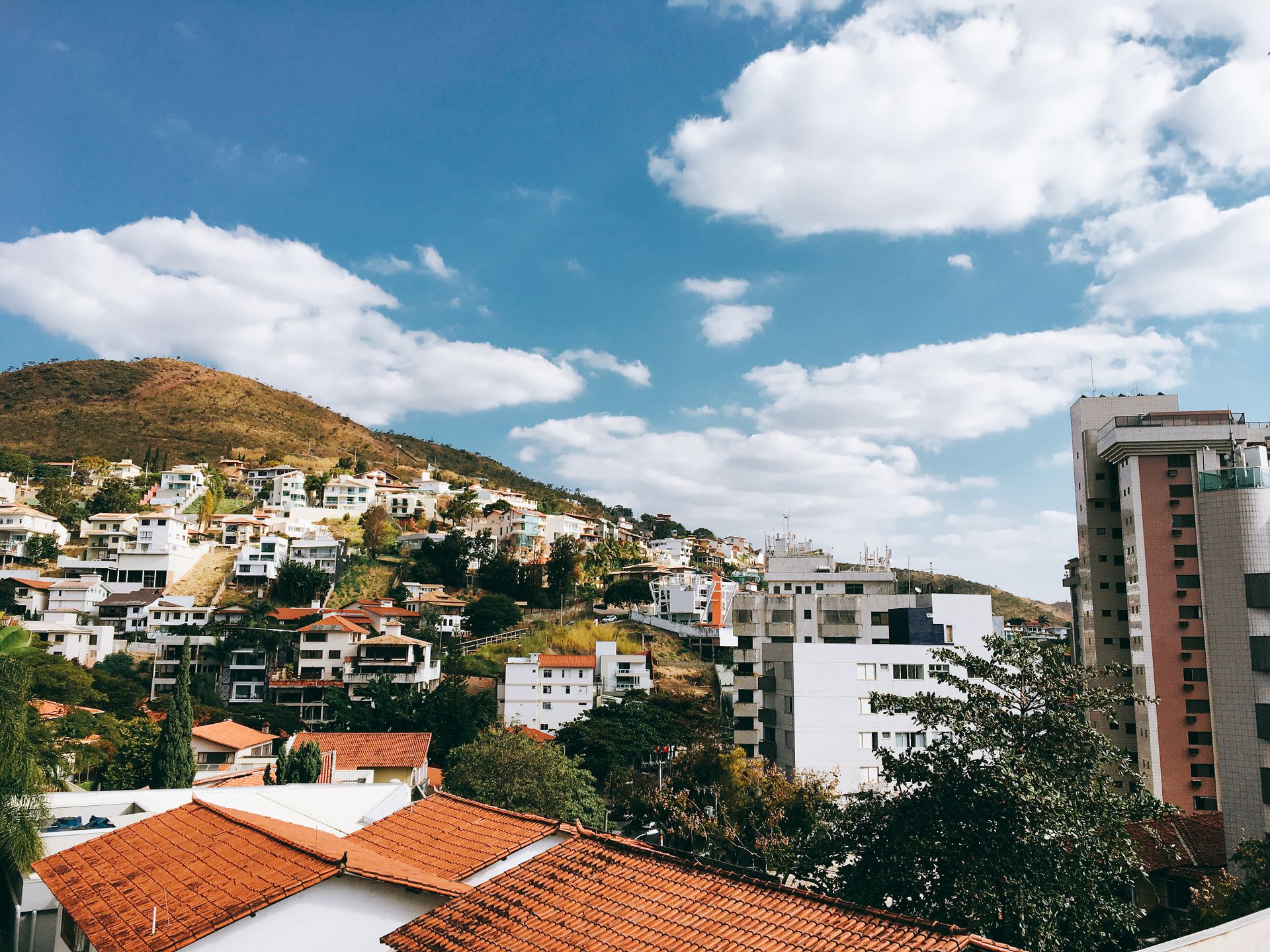 Beautiful hillside urban view with diverse architecture and clear blue skies.