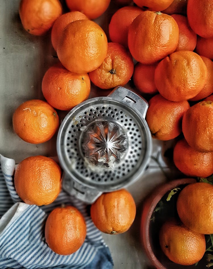 A Citrus Reamer Surrounded By Oranges